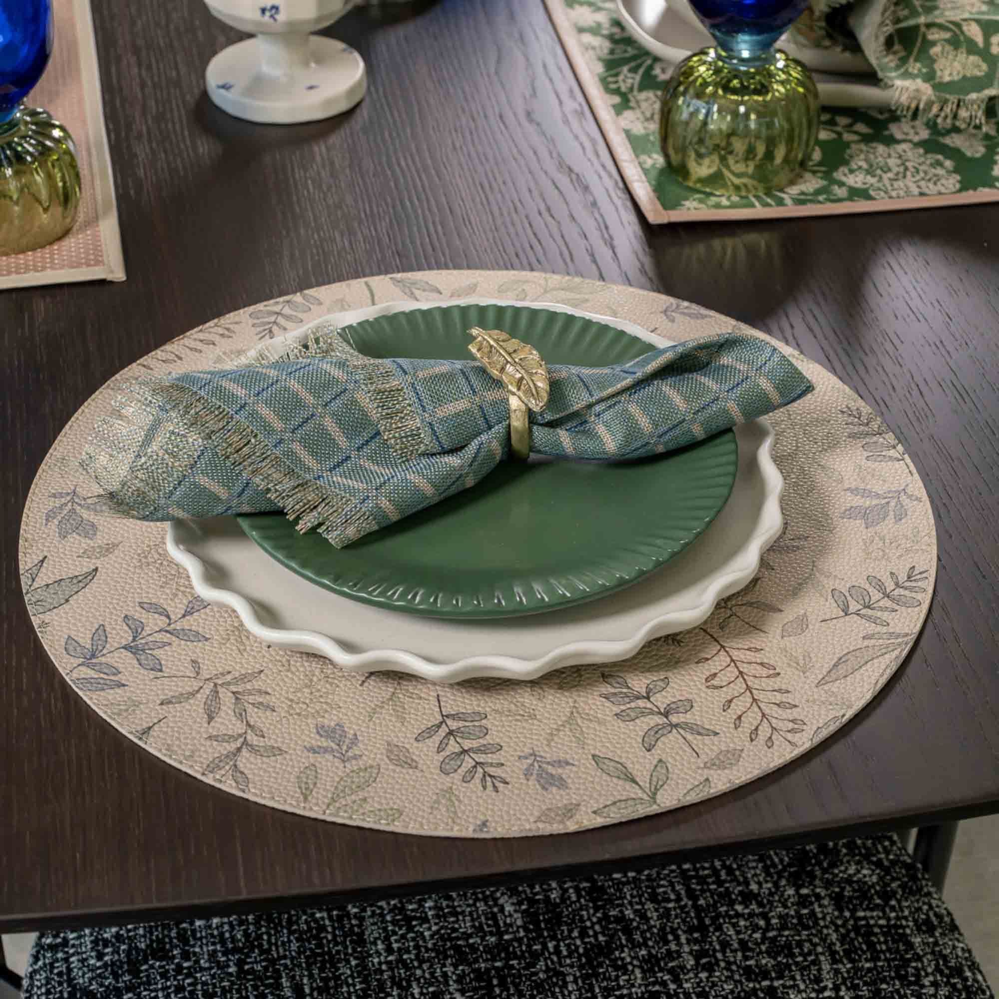 Plaid napkin with a gold ring on a green plate and a scalloped charger