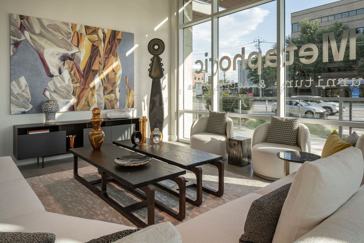 The Metaphoric showroom in Austin: armchairs, a low dark coffee table and a large painting by the front windows