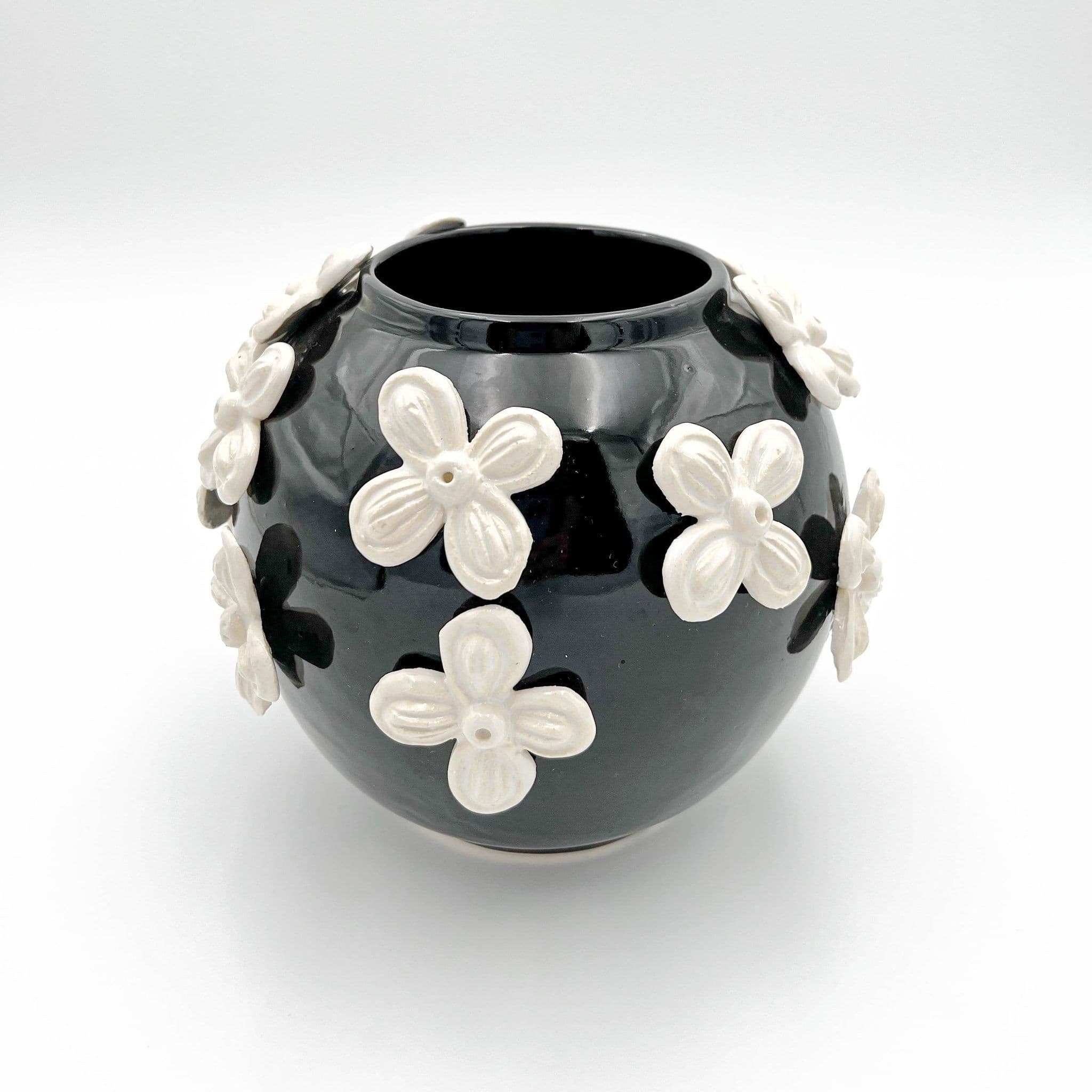 Black ceramic vase covered in raised ivory flowers